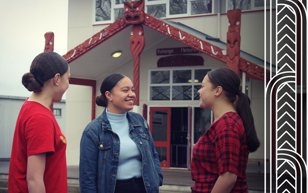 Three ākonga talk outside their school