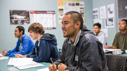 Student is listening to a teacher talk in an academy