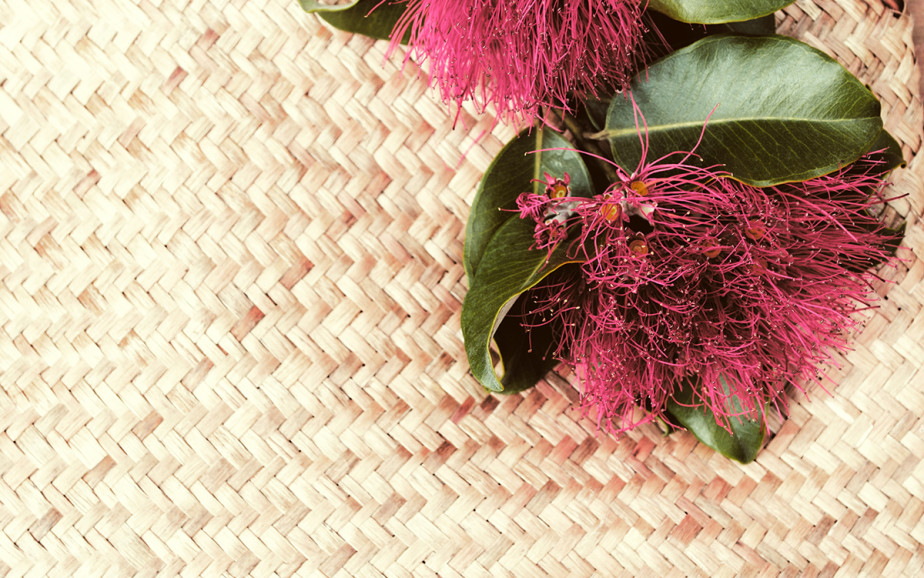 A woven mat with a pohutukawa flower