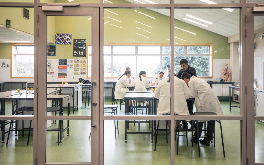 Image of a classroom with students in lab coats.