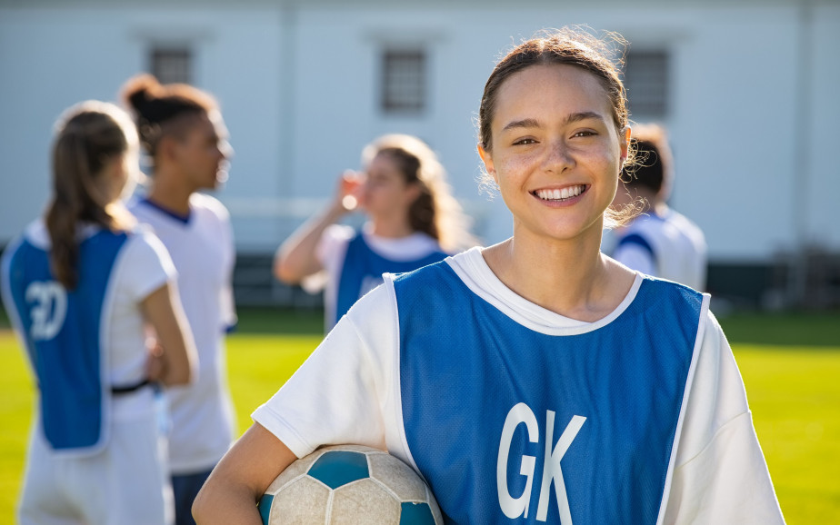 Girl holding soccer ball smiling