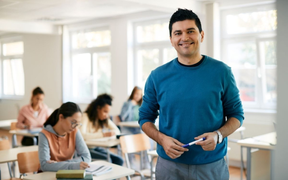 A teacher smiles at the camera