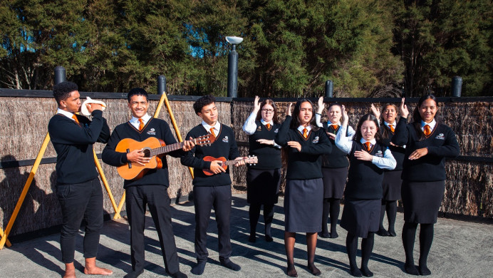 A group of students waiata a-ringa, play guitar and play the conch