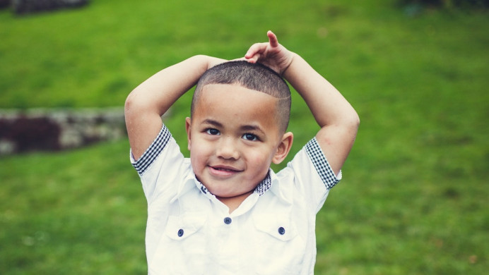 Young boy puts hands on head