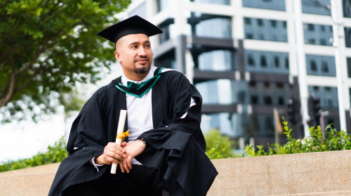 Graduate holds degree on steps of uni