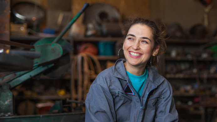 A young female mechanic smiles at the camera 