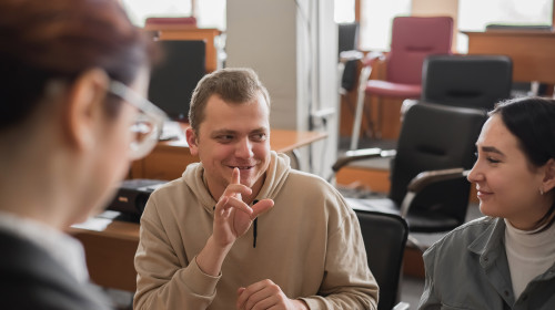 Deaf students chat in a school room.