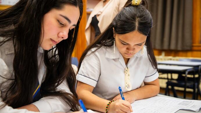 Two Te Reo Māori students study at a desk