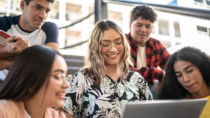 Young people sitting around a computer