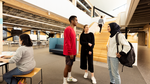 Three students stand in the hallway of their tertiary institution