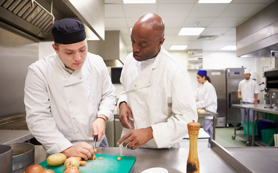 Apprentice chef and tutor in kitchen