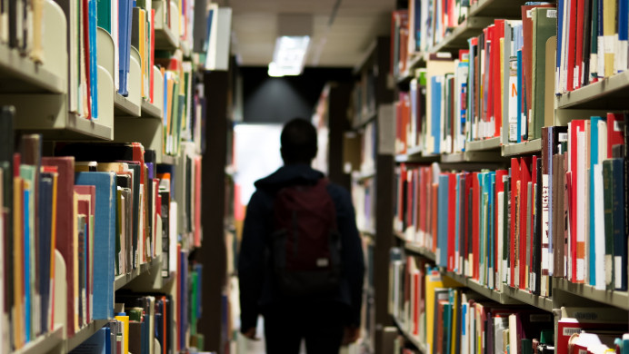 A learner walks through a library