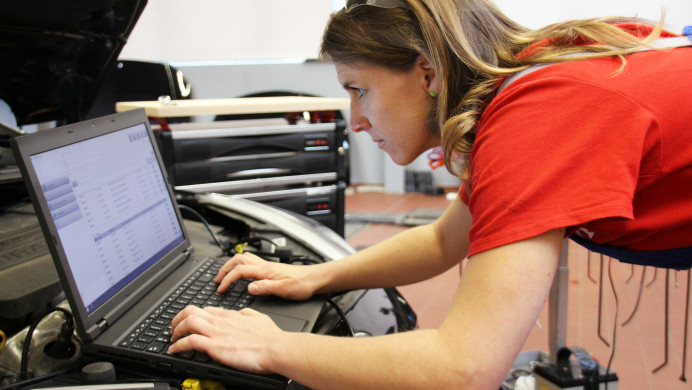 A woman in a workshop uses a computer