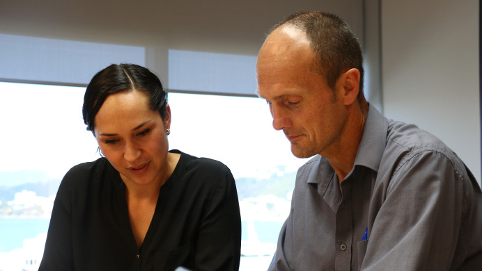 Two NZQA staff members consider an EER report