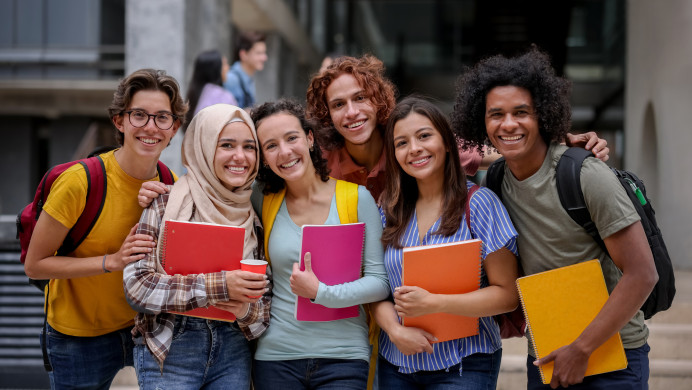 A group of tertiary students stand in their campus