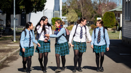 Five high school students walk towards the camera