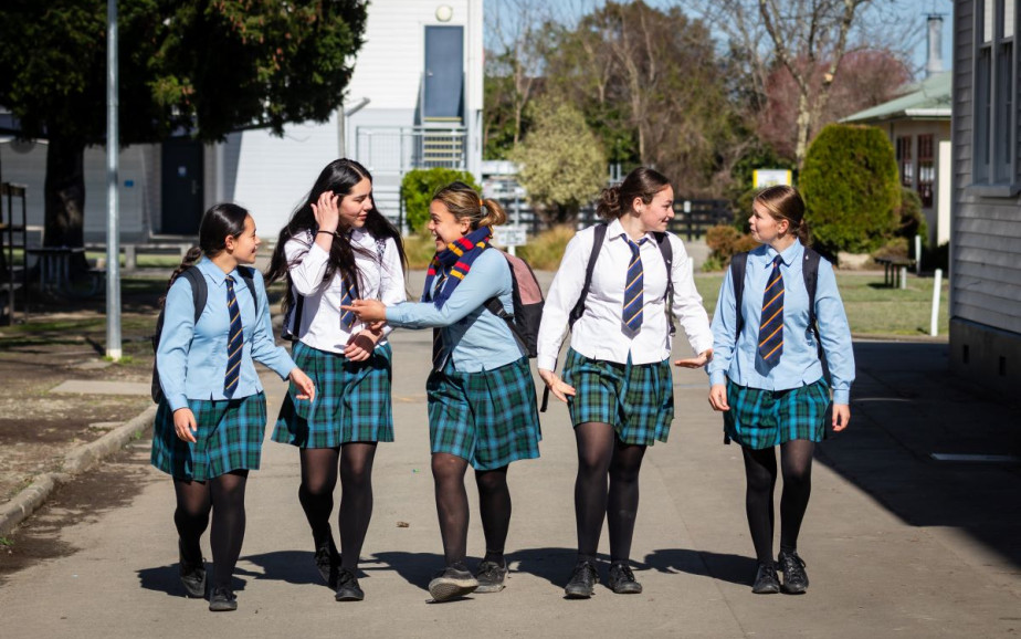 Five high school students walk towards the camera